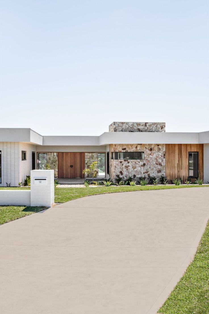 This photo shows a new home build with a concrete driveway sealed with the Dulux Avista Concrete Sealer tinted with our Merino shade. This home is by the Oak and Orange team and the photo is by The Palm Co. White Concrete Driveway, Beige Driveway, Driveway Ideas Concrete, Sandstone Driveway, Stained Concrete Driveway Ideas, Coastal Driveway, Concrete Driveway Ideas, Concrete Driveway Paint, Stained Concrete Driveway