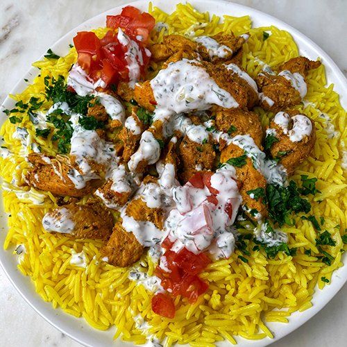 a white plate topped with rice and meat