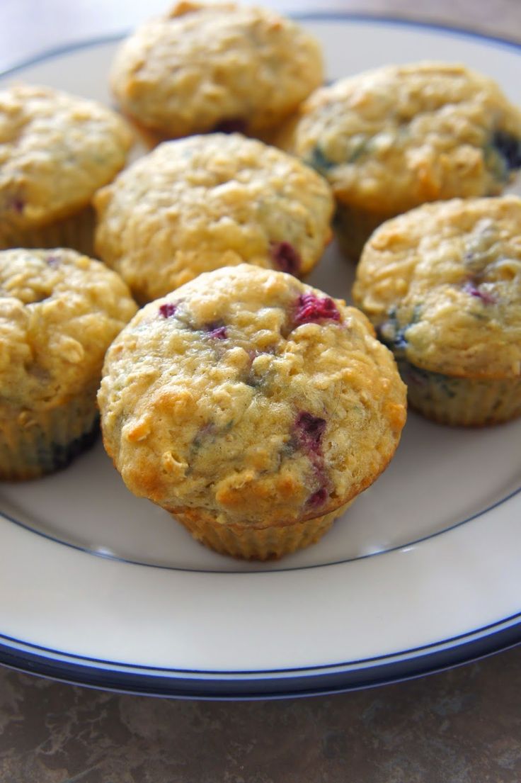 blueberry muffins on a white plate sitting on a table