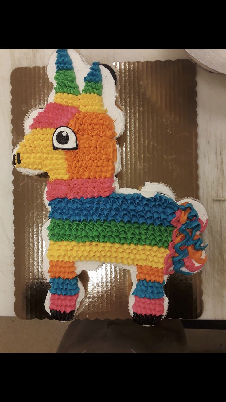 a cake shaped like a llama with multicolored icing