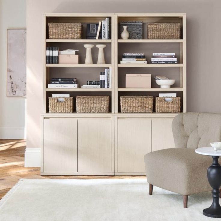 a living room filled with furniture and bookshelves next to a white rug on top of a hard wood floor