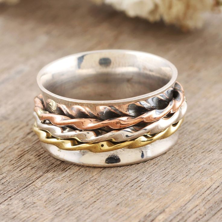 Ancient Tibetan prayer wheels are recreated in meditation spinner rings such as this lovely creation by India's Shivani Choudhary in sterling silver, brass and copper. A wide sterling silver band holds the multi-metal twisted and rotating bands you can spin to achieve tranquility and peace of mind. Spinning Rings, Brass And Copper, Spinner Ring, Spinner Rings, Sterling Silver Bands, Silver Band, Metal Working, Women Rings, Spinning