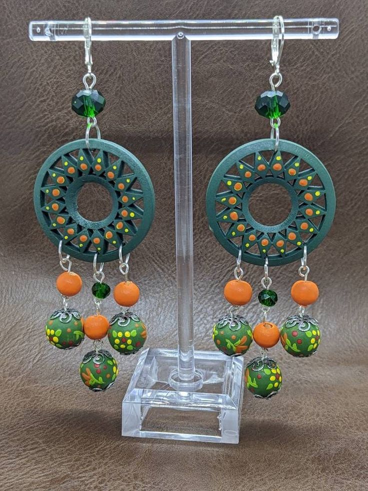 Beautiful hand painted wooden earrings with glass beads. Really fun and colorful to wear. Bohemian Green Polymer Clay Earrings, Green Bohemian Polymer Clay Earrings, Bohemian Hand-painted Resin Earrings, Bohemian Hand Painted Resin Earrings, Green Hand-painted Bohemian Earrings, Green Hand Painted Bohemian Earrings, Unique Green Earrings With Colorful Beads, Bohemian Multicolor Wooden Bead Earrings, Artsy Green Earrings For Festival