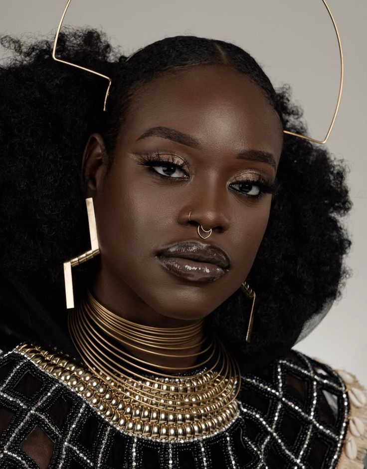 a woman with large hoop earrings and gold jewelry on her head, wearing an afro wig