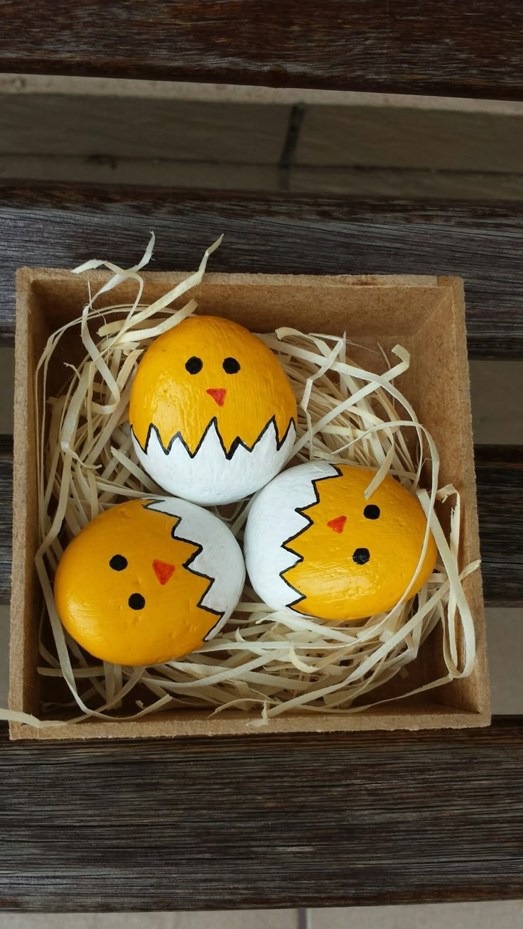 three decorated eggs in a cardboard box