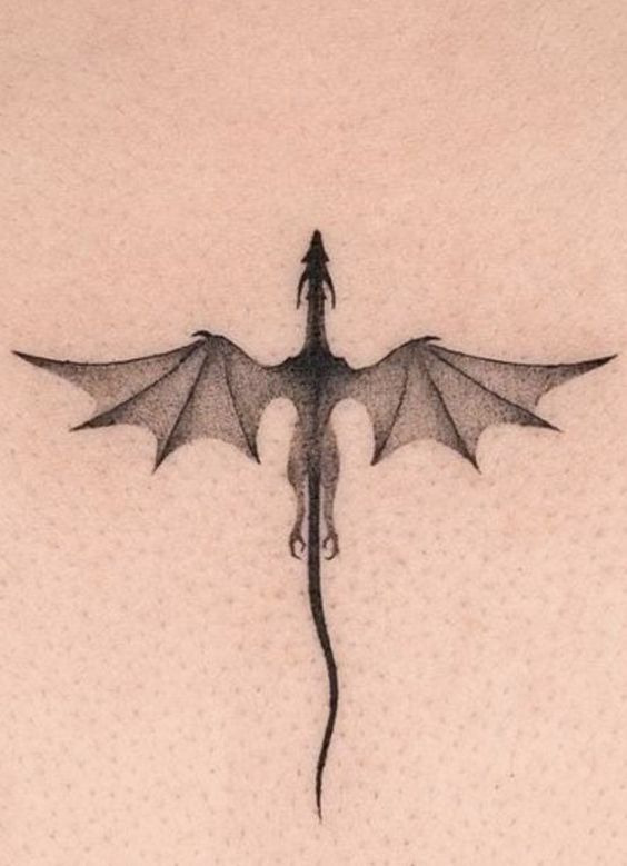 a black and white photo of a dragon on the back of a woman's stomach