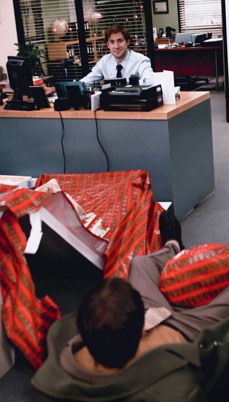 a man sitting at a desk in an office with his feet up on the floor