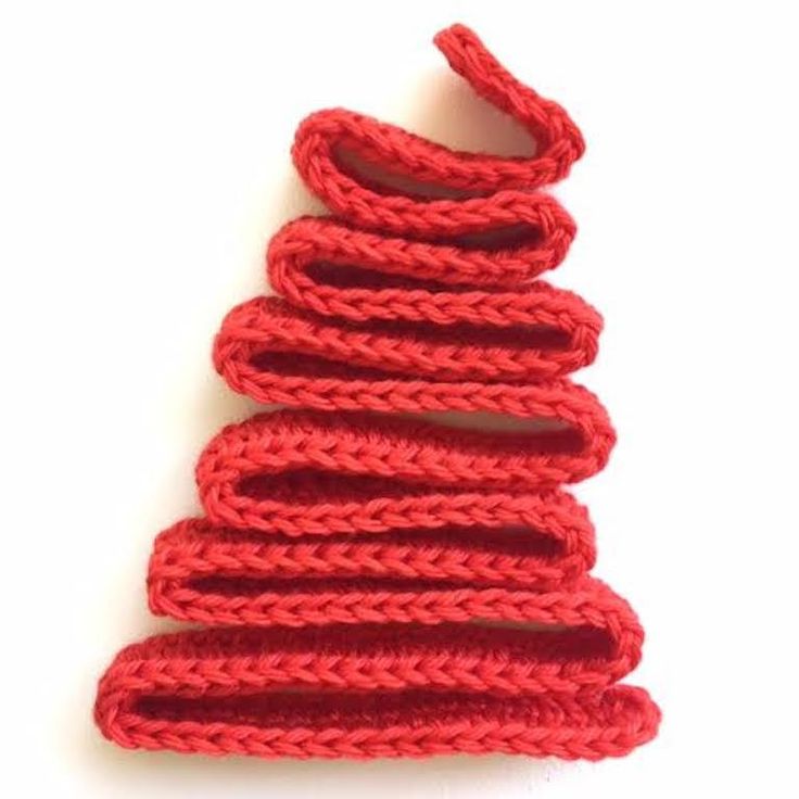 red crocheted christmas tree ornament on white background