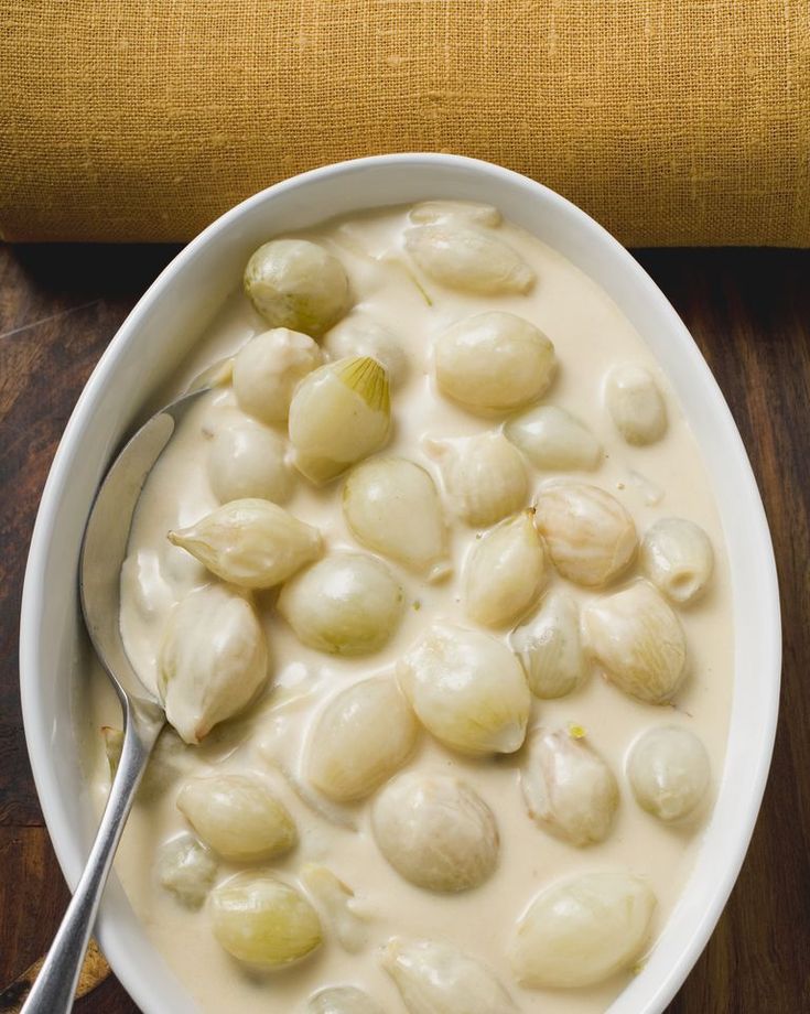 a white bowl filled with food on top of a wooden table