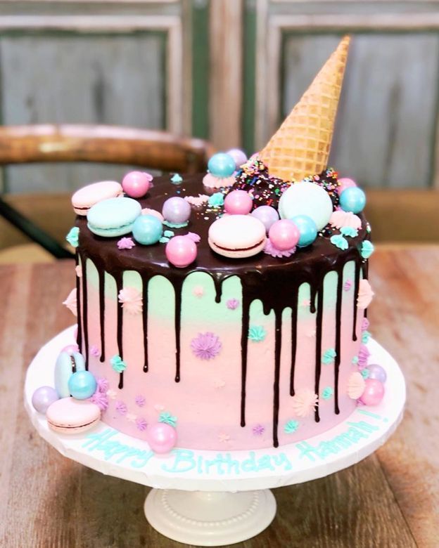 a cake with chocolate icing and marshmallows on top sitting on a table