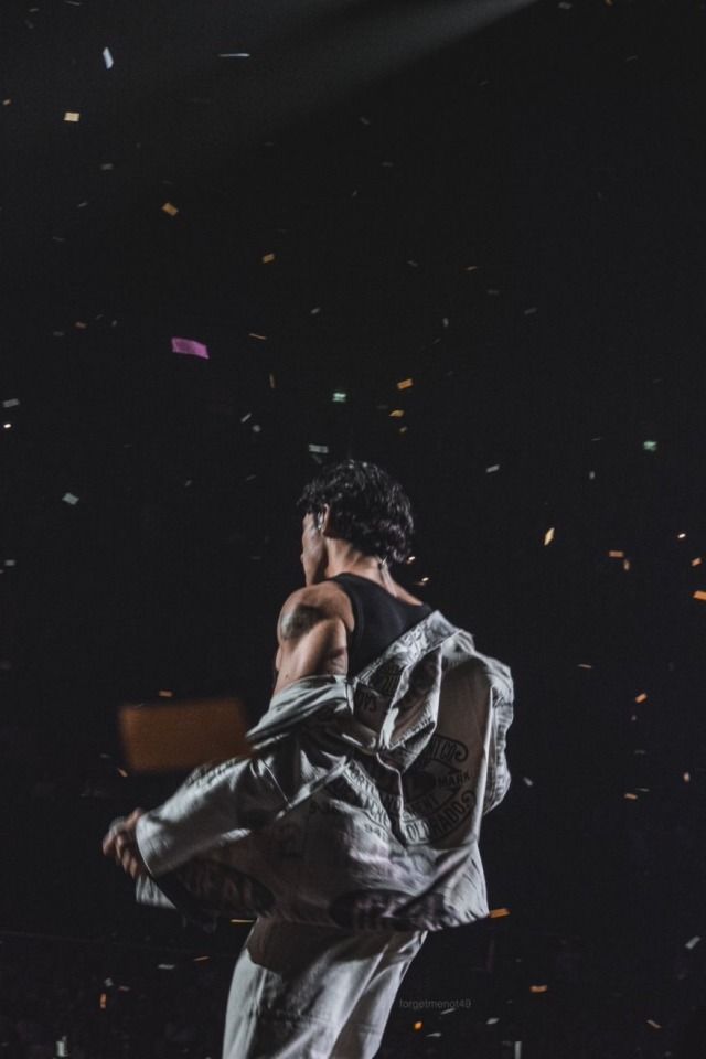 a man standing on top of a stage with confetti in the air behind him