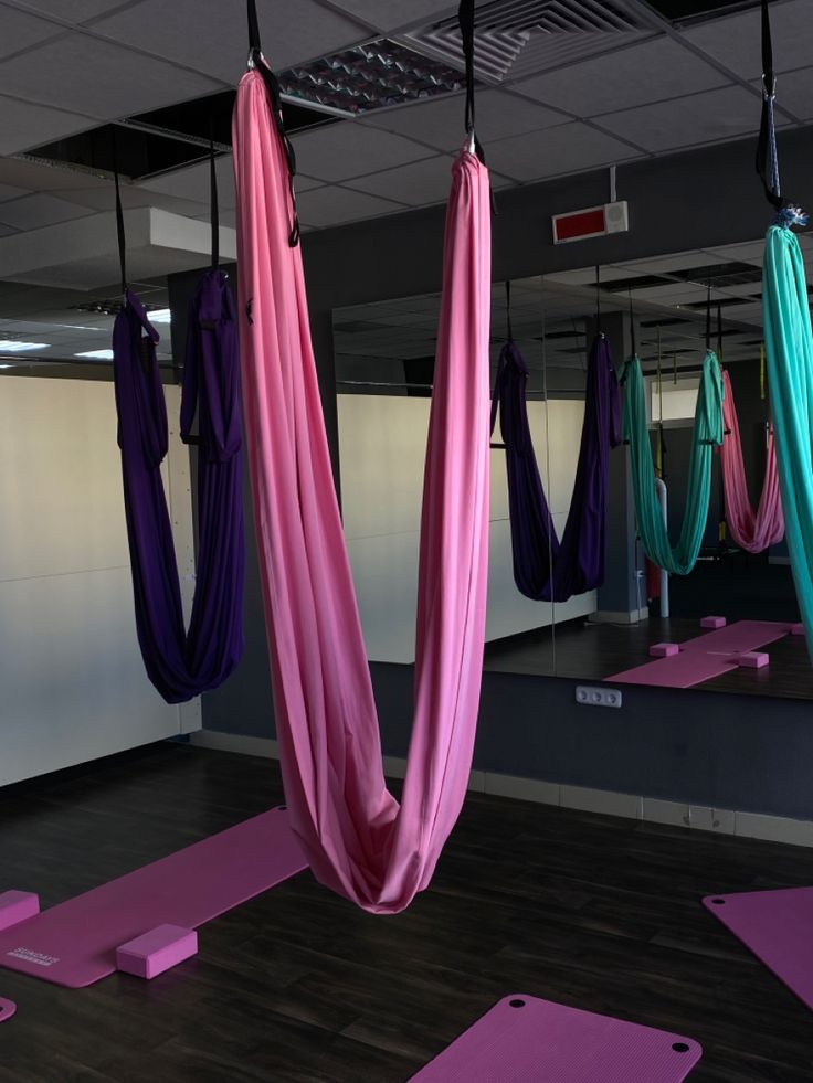 yoga mats and hammocks are hanging from the ceiling in an office gym area