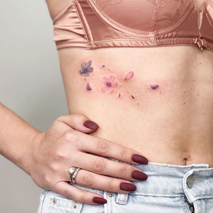 a woman's stomach with small pink flowers on her left side, and the bottom part of her belly