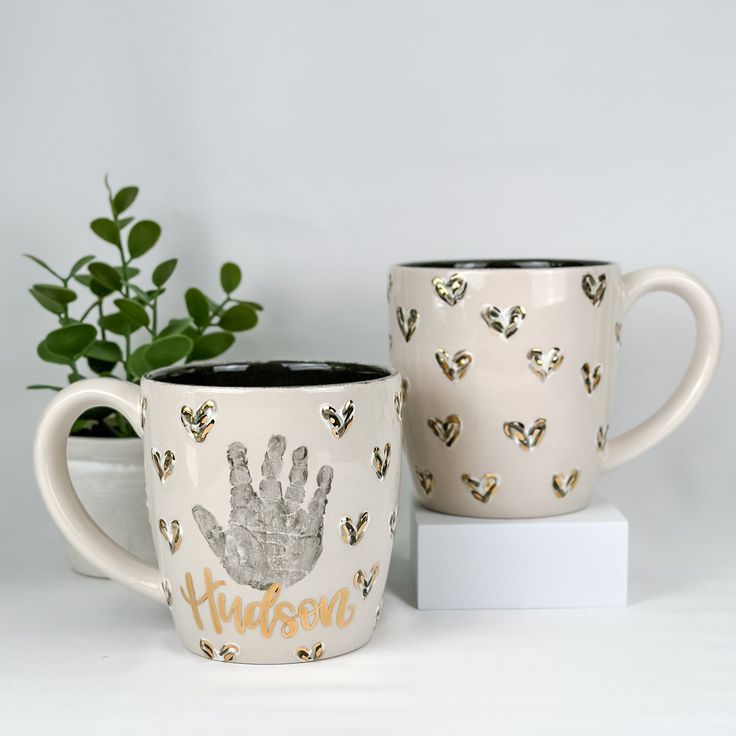 two coffee mugs sitting next to each other on top of a white countertop