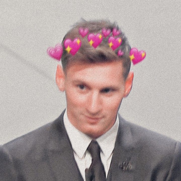 a man in a suit and tie with pink hearts on his head is looking at the camera