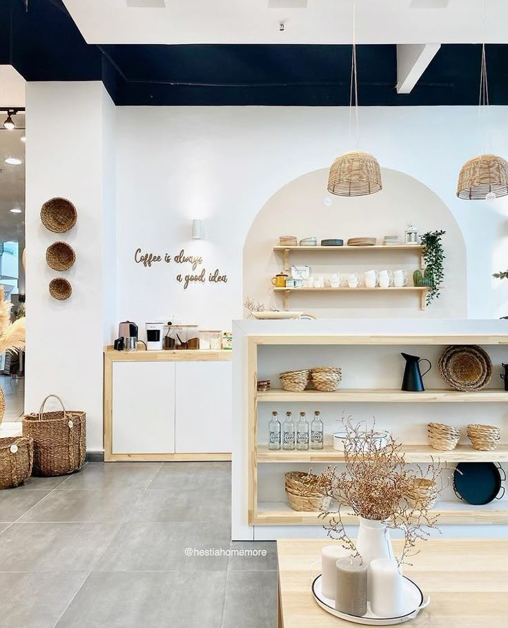 the interior of a store with white walls and wooden shelves