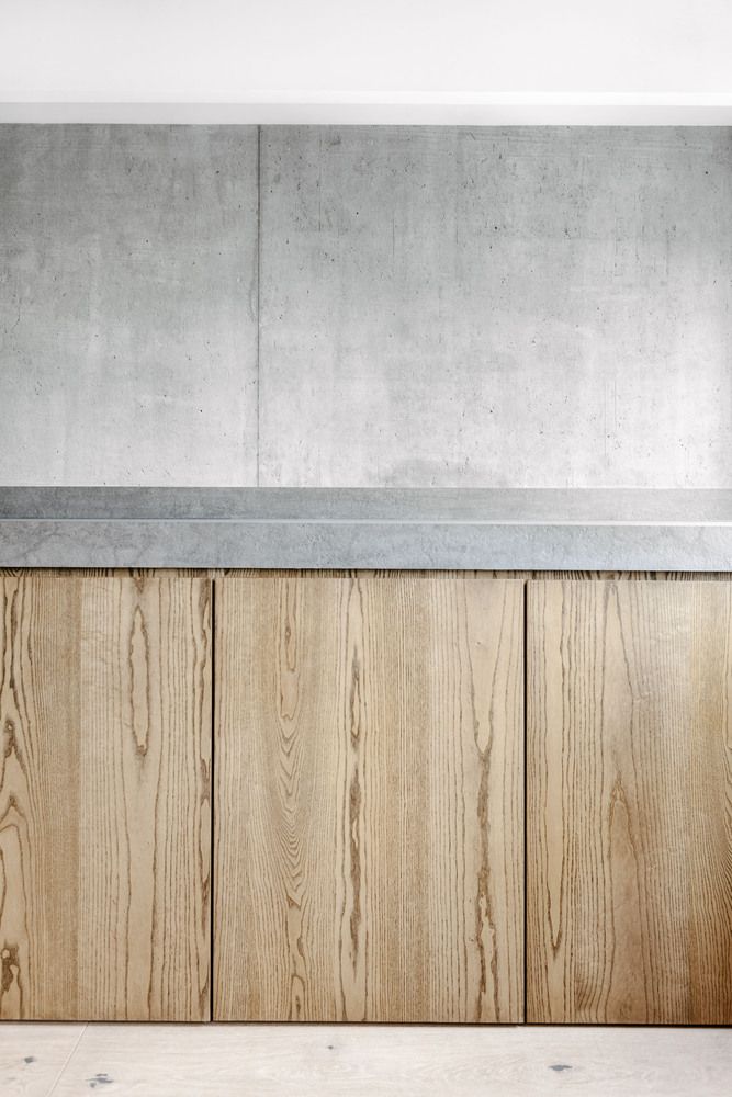 an empty room with wood paneling and concrete counter tops on the wall, in front of a window