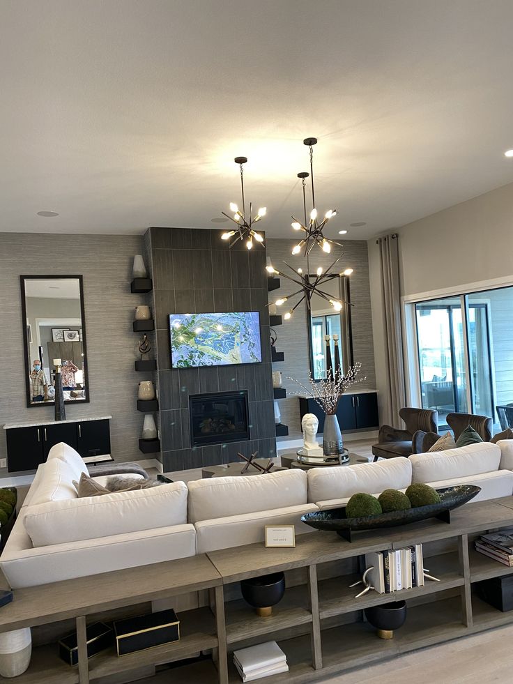 a living room filled with lots of furniture and a flat screen tv mounted to the wall