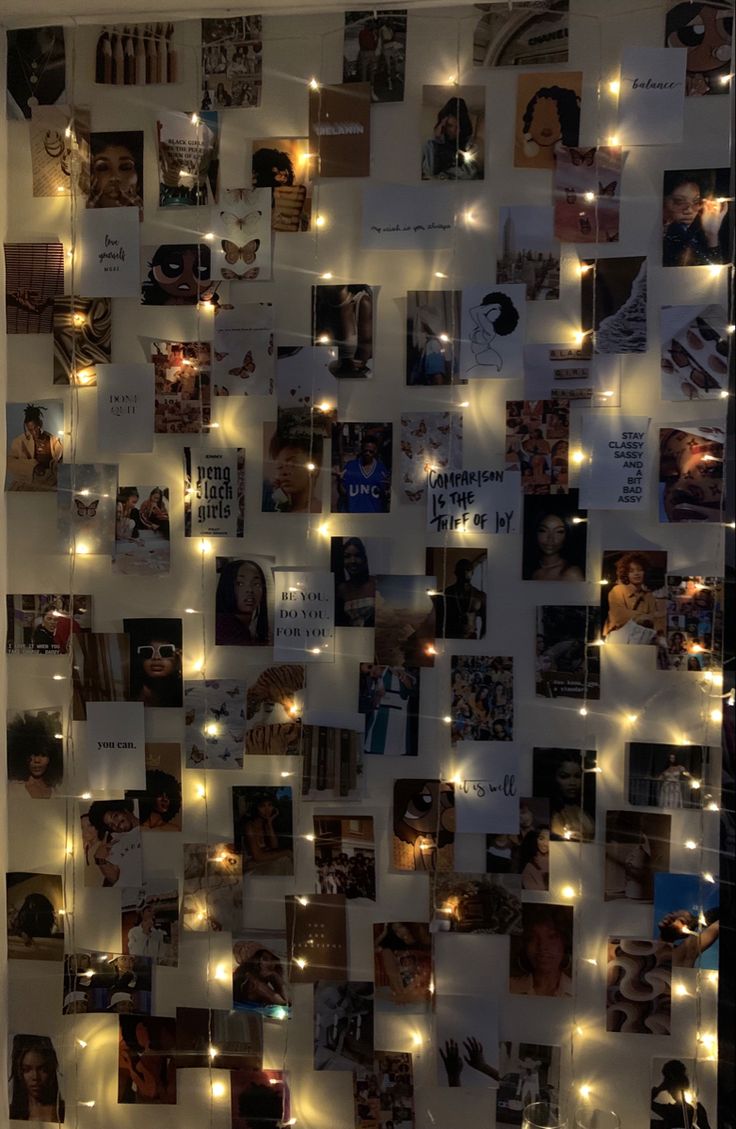 a wall covered in photos and lights with pictures on it's side, all lit up