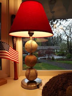 a baseball lamp sitting on top of a table next to a window with an american flag