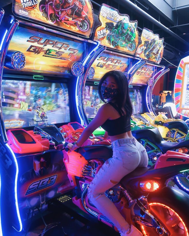 a woman sitting on a motorcycle in front of slot machines