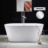 a white bath tub sitting in a bathroom next to a mirror and vase with flowers