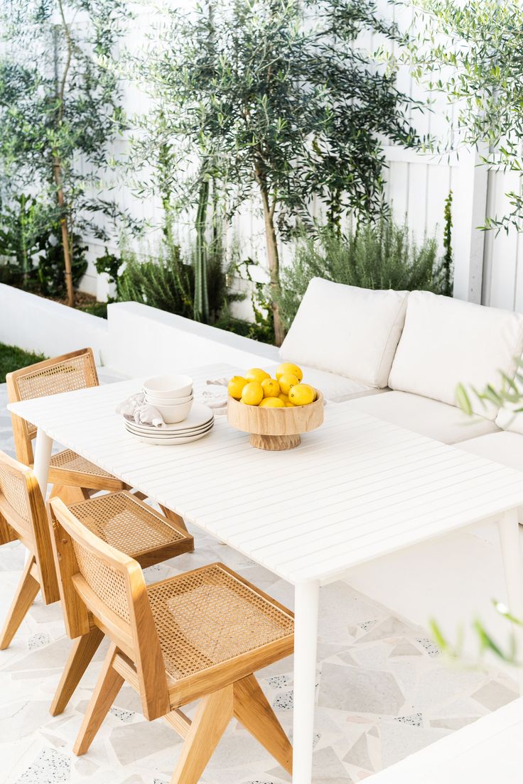 a table that has some lemons on it in the middle of a patio area