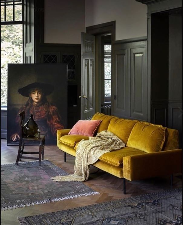 a living room with a yellow couch and painting