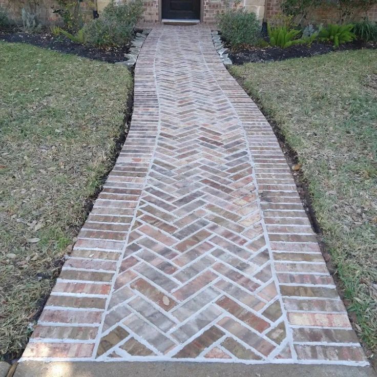 a brick walkway in front of a house