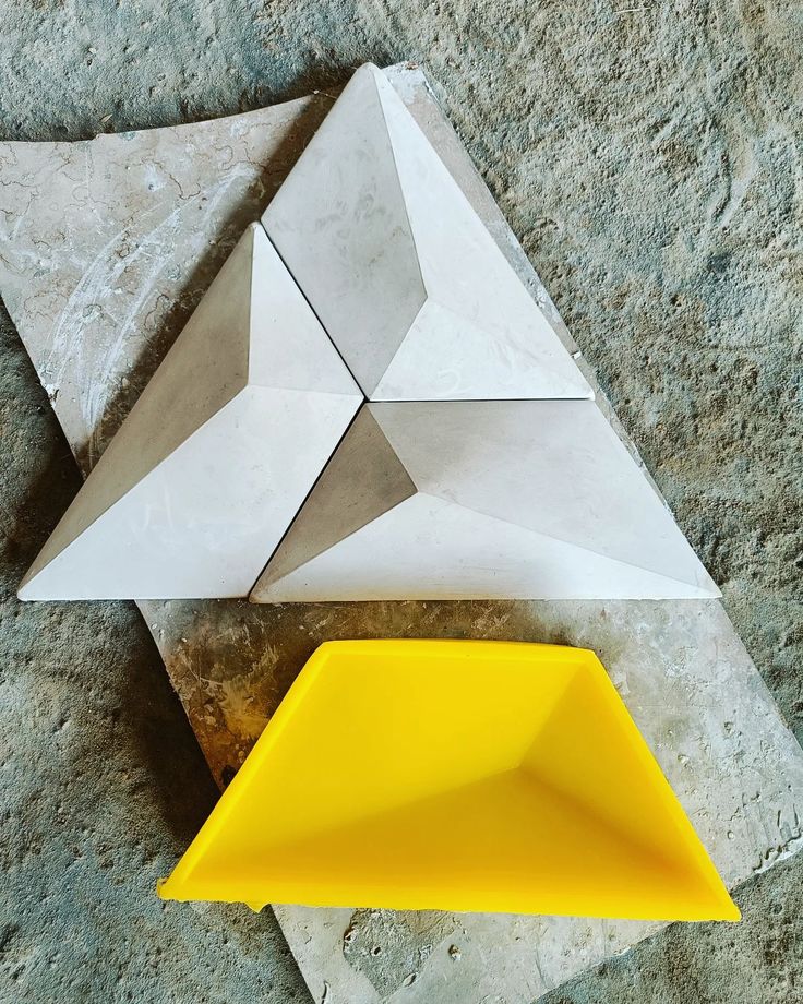 two pieces of origami sitting on top of a stone floor next to each other