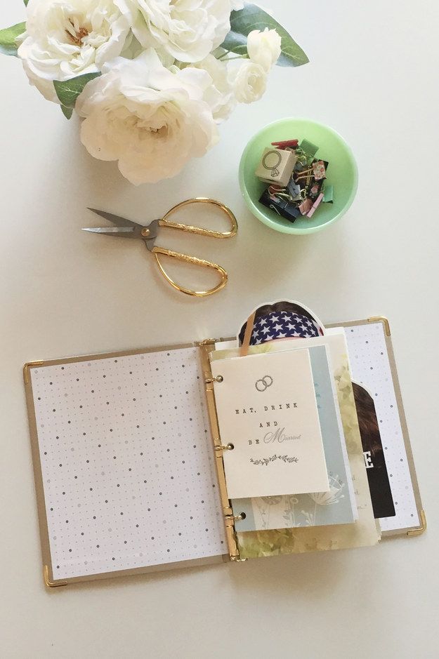 an open planner book sitting on top of a table next to a bowl of flowers