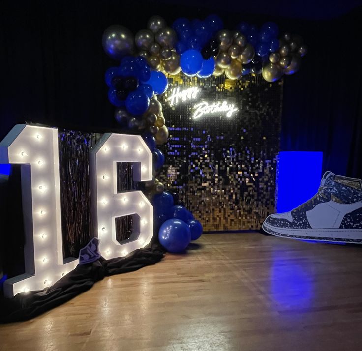 a room with balloons and lights that spell out the number 16 in front of it