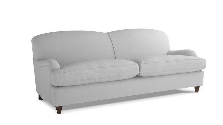 a white couch sitting on top of a white floor next to a wooden leg chair