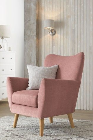 a pink chair sitting on top of a white rug