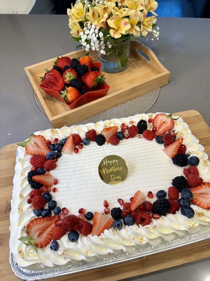 a birthday cake decorated with strawberries and blueberries