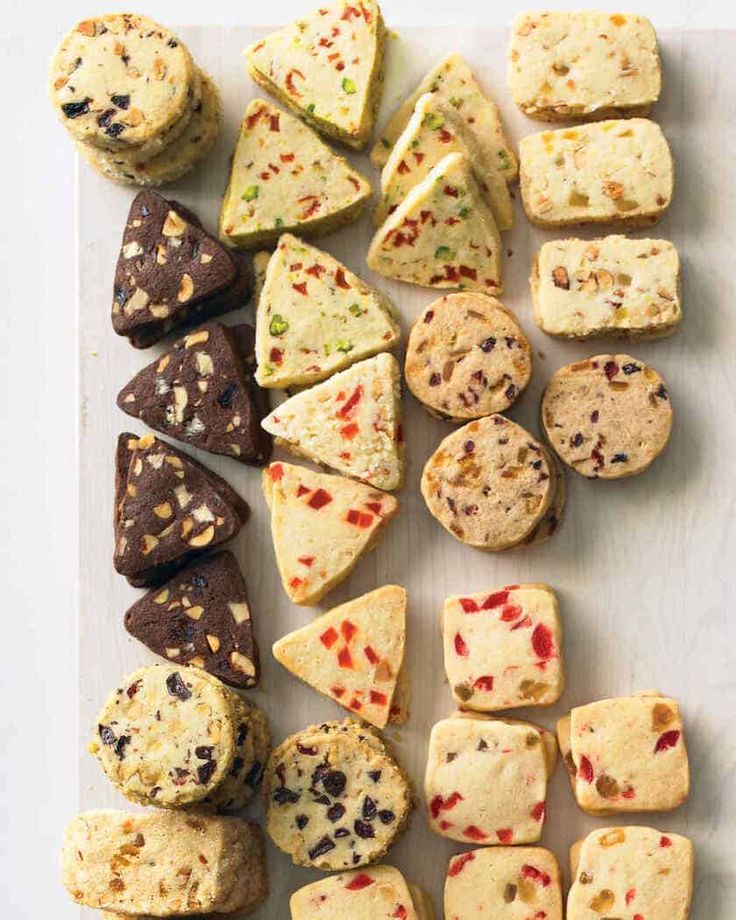 a white cutting board topped with different types of cookies