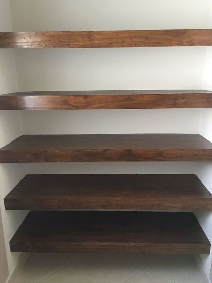 three wooden shelves in the corner of a room