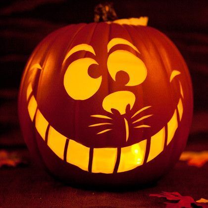 a carved pumpkin with an angry cat face on it's face, lit up at night