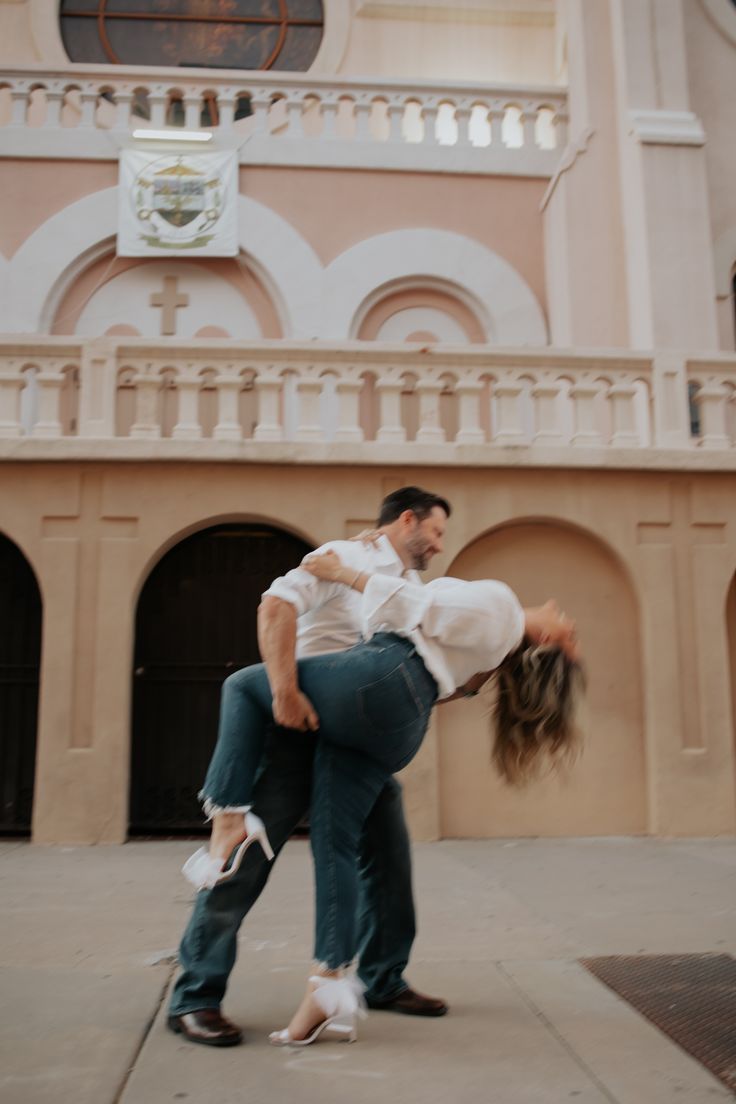 a man and woman dancing in front of a building