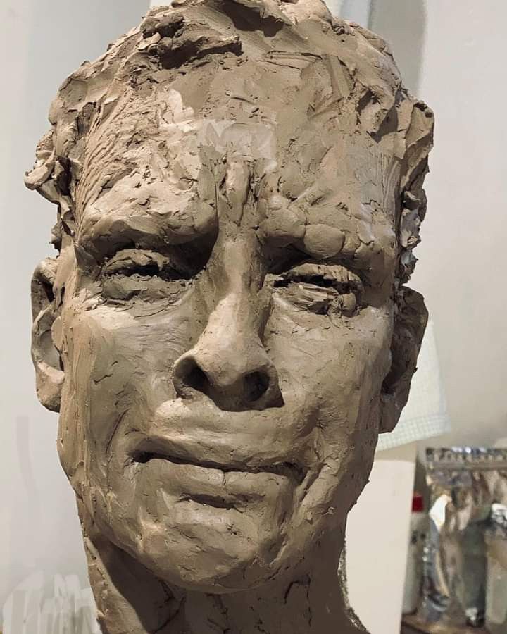 a clay sculpture of a man's face is shown