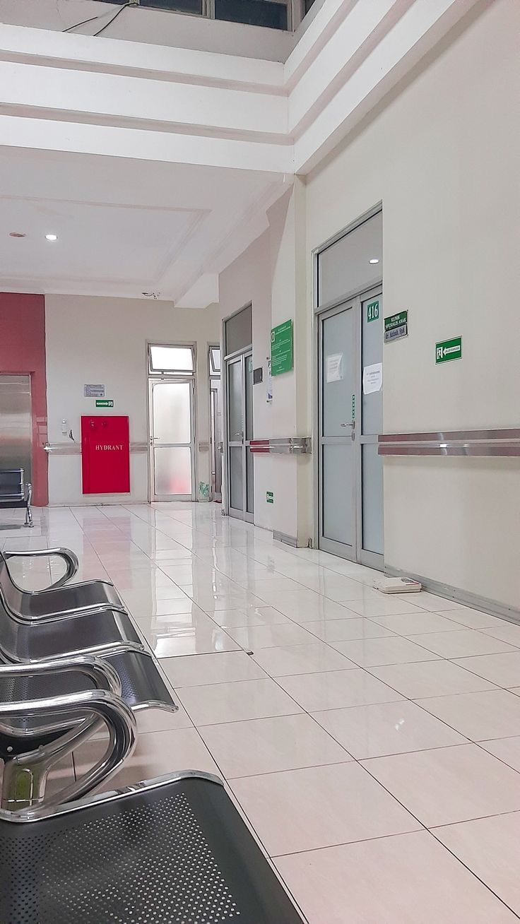 an empty lobby with two metal benches and red doors