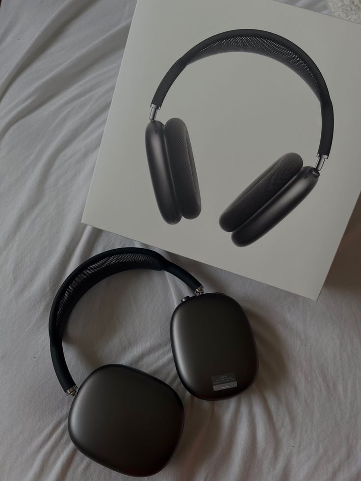 an image of headphones laying on top of a bed next to a card with the same design