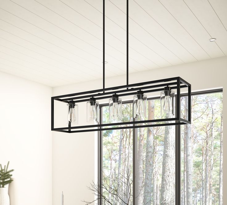 This 5 light rectangular chandelier is unique and perfect decoration for the modern or farmhouse home, minimal lines and modern tones give the light an edge that never disappoints. The corners of its simple cage frame are accented by square blocks, all finished in a deep earth black with clear glass. Perfectly for kitchen island, dining room, living room, cafe, bar, club, warehouse, hallway. Aiwen 5-Light Black Farmhouse Chandelier | US-DK-CIC-B5 Black Iron Light Fixtures, Dining Room Black Light Fixtures, Dining Room Light Fixtures Rectangle, Modern Farmhouse Dining Room Chandelier, Frame Kitchen Island, Townhouse Upgrades, Rectangle Light Fixture, Farmhouse Chandelier Dining Rooms, Linear Kitchen Island Lighting