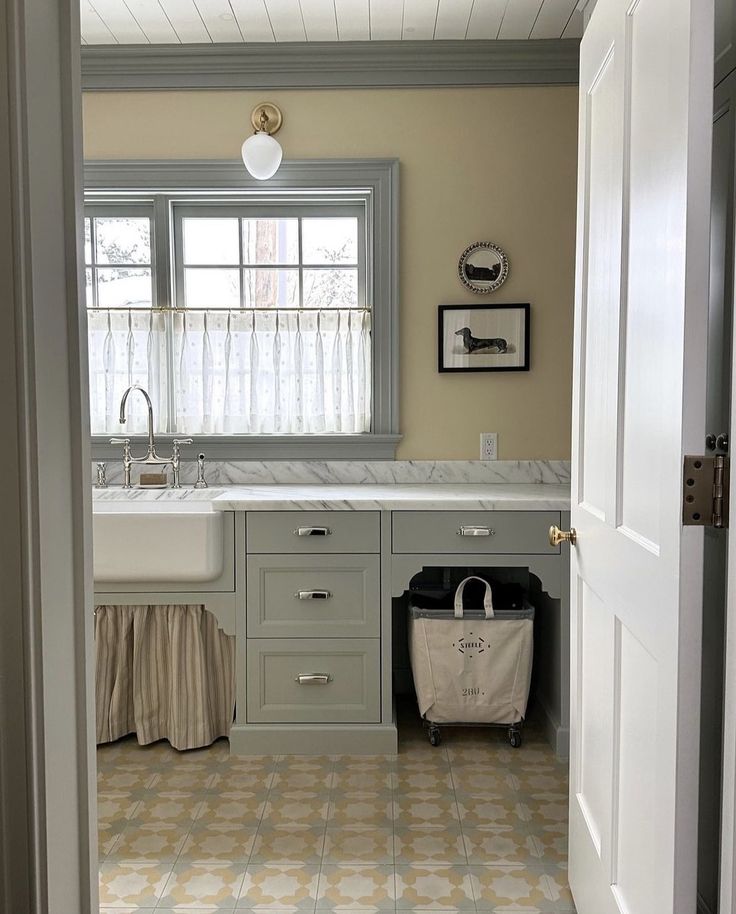 an open door leading to a kitchen with a sink and counter top in the corner