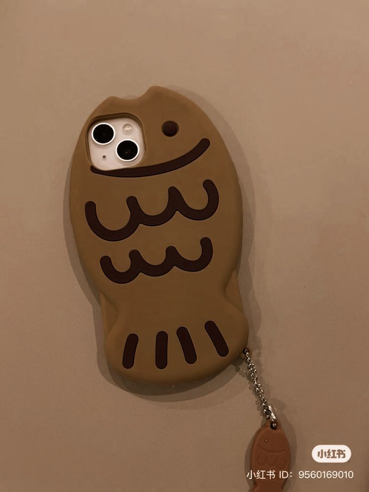 a cell phone case with an owl design on the front and back cover, attached to a keychain