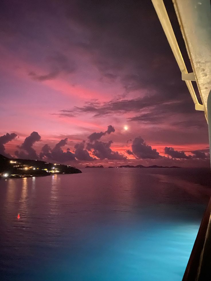 the sun is setting over the ocean with clouds in the sky and water below it