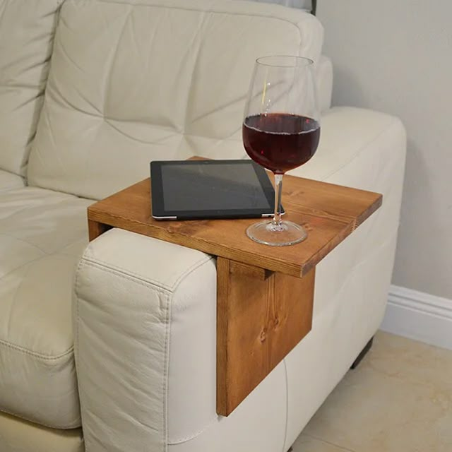 a glass of wine sitting on top of a wooden table next to a white couch