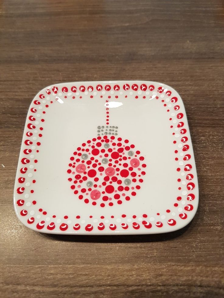 a white plate with red dots on it sitting on top of a wooden table next to a knife and fork