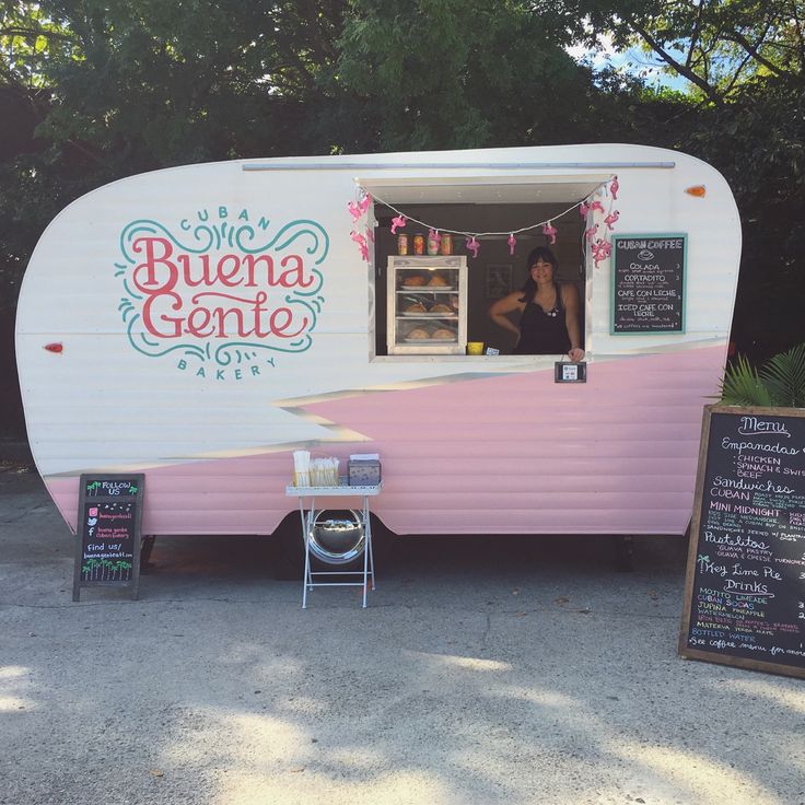 a pink and white trailer parked next to a chalkboard with the word buena gente written on it