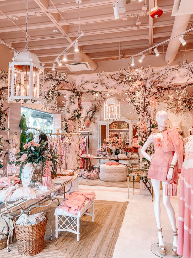 a room filled with mannequins and pink dresses